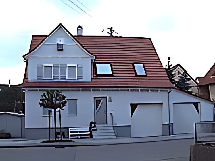 Haus mit Fensterläden und Tür in Salbei-Grau